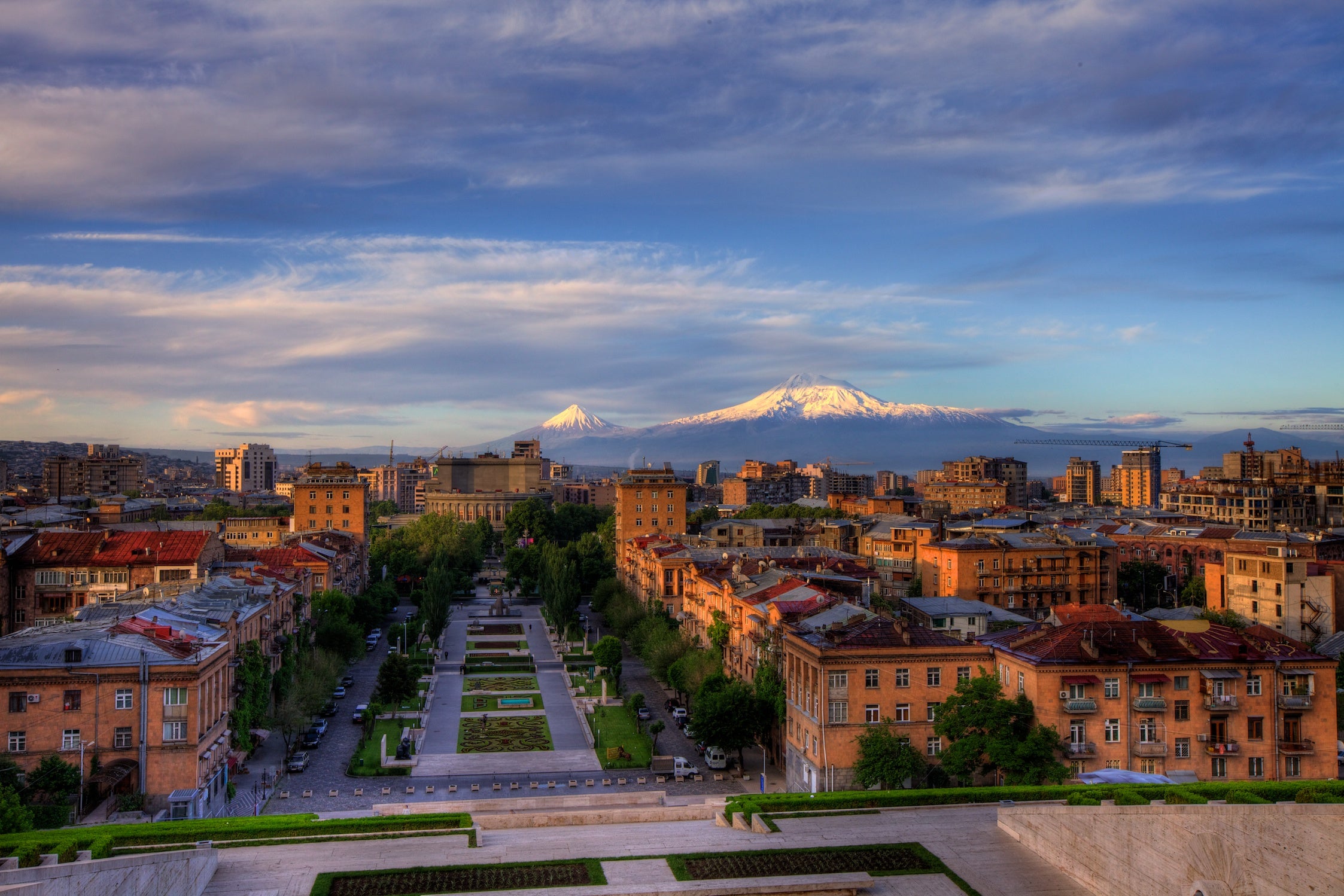 Yerevan with buildings and a mountain under a cloudy sky